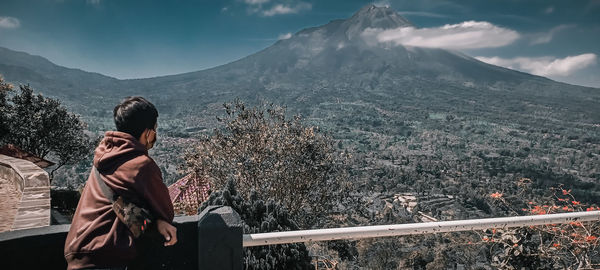 Woman looking at mountains against sky