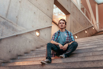 Portrait of young man sitting on staircase