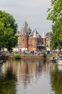 Buildings by river against sky