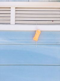 Close-up of yellow sign hanging on building