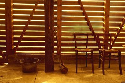 Empty chairs and tables in illuminated room