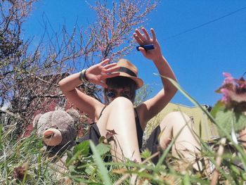 Low angle view of people by plants against sky