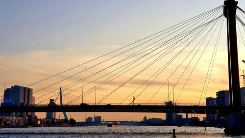 View of suspension bridge over river against sky