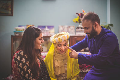 Friends looking at bride in home