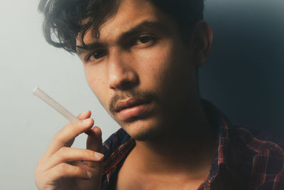 Portrait of young man smoking cigarette