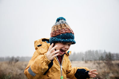 Young boy laughing playing outside in the snow