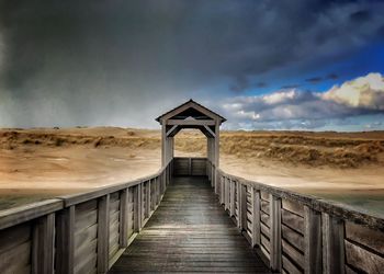Bridge over calm sea against sky