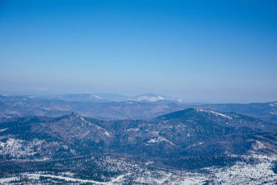 Aerial view of mountain range against clear blue sky