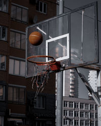 Low angle view of basketball hoop against buildings in city