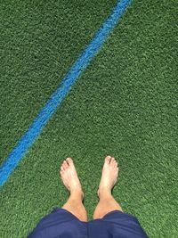 Low section of man standing on soccer field