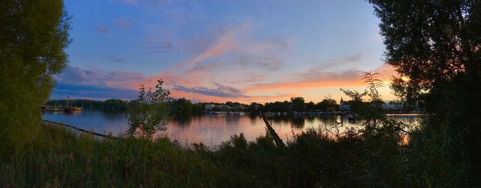 Scenic view of calm lake against sky during sunset