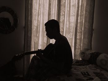 Man sitting on bed at home