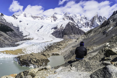 Rear view of person on snowcapped mountains against sky