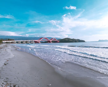 Scenic view of beach against cloudy sky