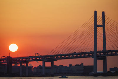 Low angle view of suspension bridge against sky during sunset