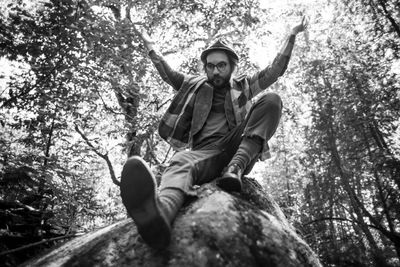 Low angle view of smiling man in forest