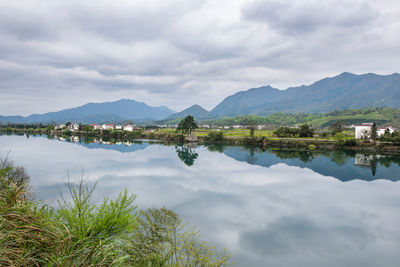 Scenic view of lake by mountains against sky