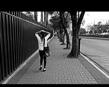 Rear view of woman walking on footpath