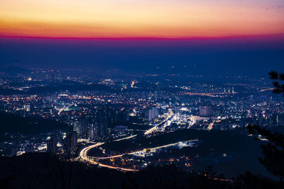 High angle view of illuminated city against sky at night