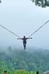 A man swing in the sky by rope