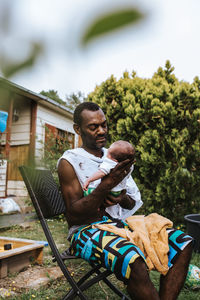 Man sitting on chair in yard