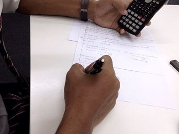 High angle view of human hand on paper