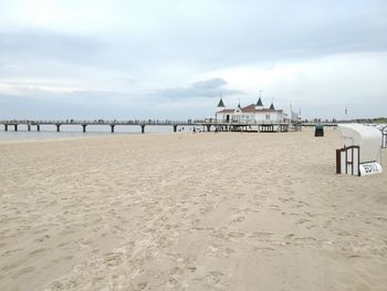 Wooden posts on beach against sky