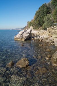 Rock formation on beach against clear sky