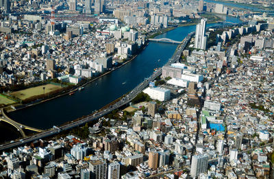 High angle view of crowd by river against buildings in city