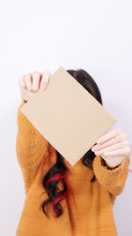 Midsection of woman holding box against white background