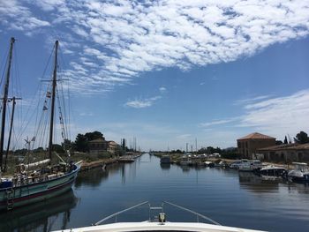 Boats moored at harbor against sky