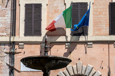 Low angle view of flags hanging against building