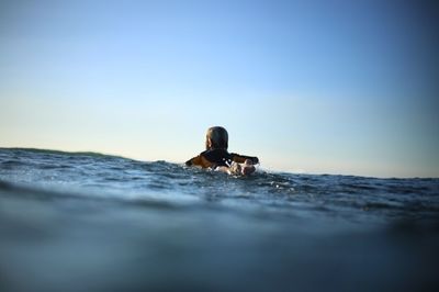 Man and woman in sea against clear sky