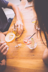 High angle view of woman holding drink sitting on table