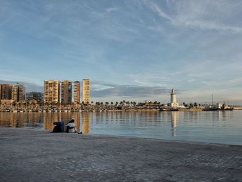 Scenic view of sea by buildings against sky