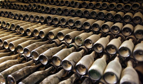 Full frame shot of dust covered wine bottles in warehouse