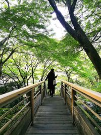 Man standing by railing against sky