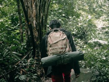 Rear view of man standing in forest