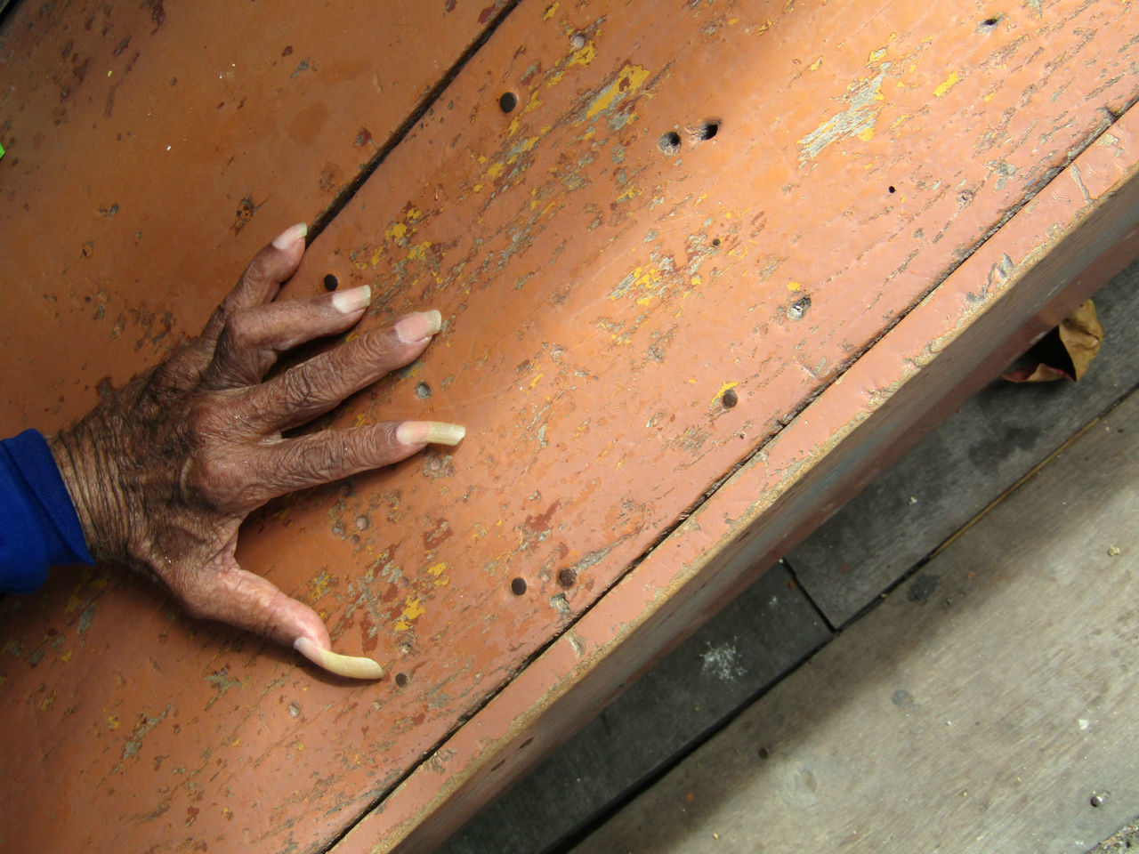 CLOSE-UP OF HUMAN HAND ON WOOD