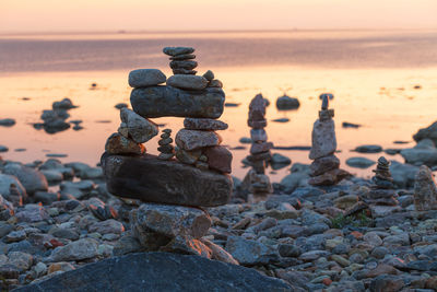 Stack of stones on beach during sunset