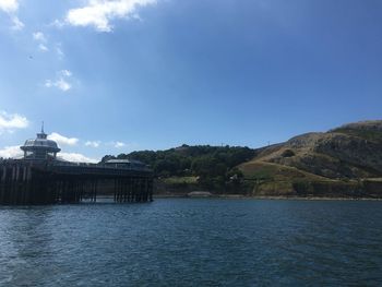 Buildings by lake against blue sky