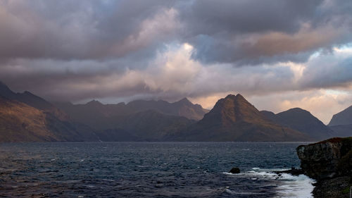 Scenic view of sea and mountains against sky