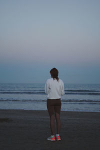 Rear view of woman standing on beach