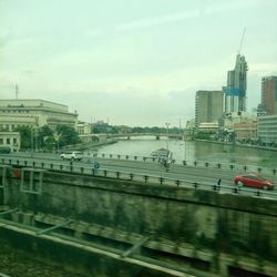 Aerial view of bridge over river against sky in city