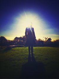 People on grassy field at sunset