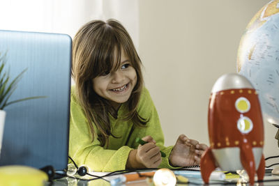Portrait of a smiling girl on table at home