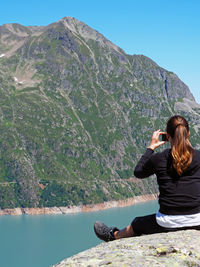 Rear view of woman standing on lakeshore