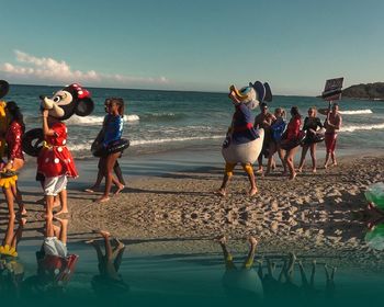 People at beach against sky
