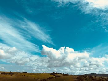 Low angle view of landscape against blue sky