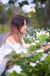 Portrait of young woman standing amidst plants